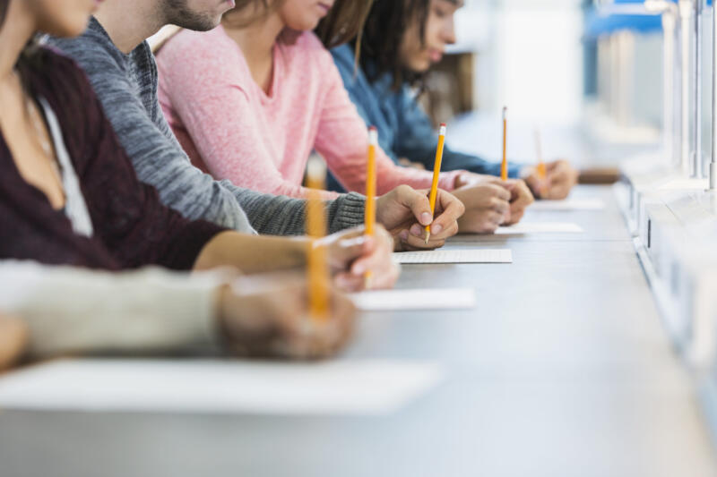 Cropped view of group of teenagers taking a test